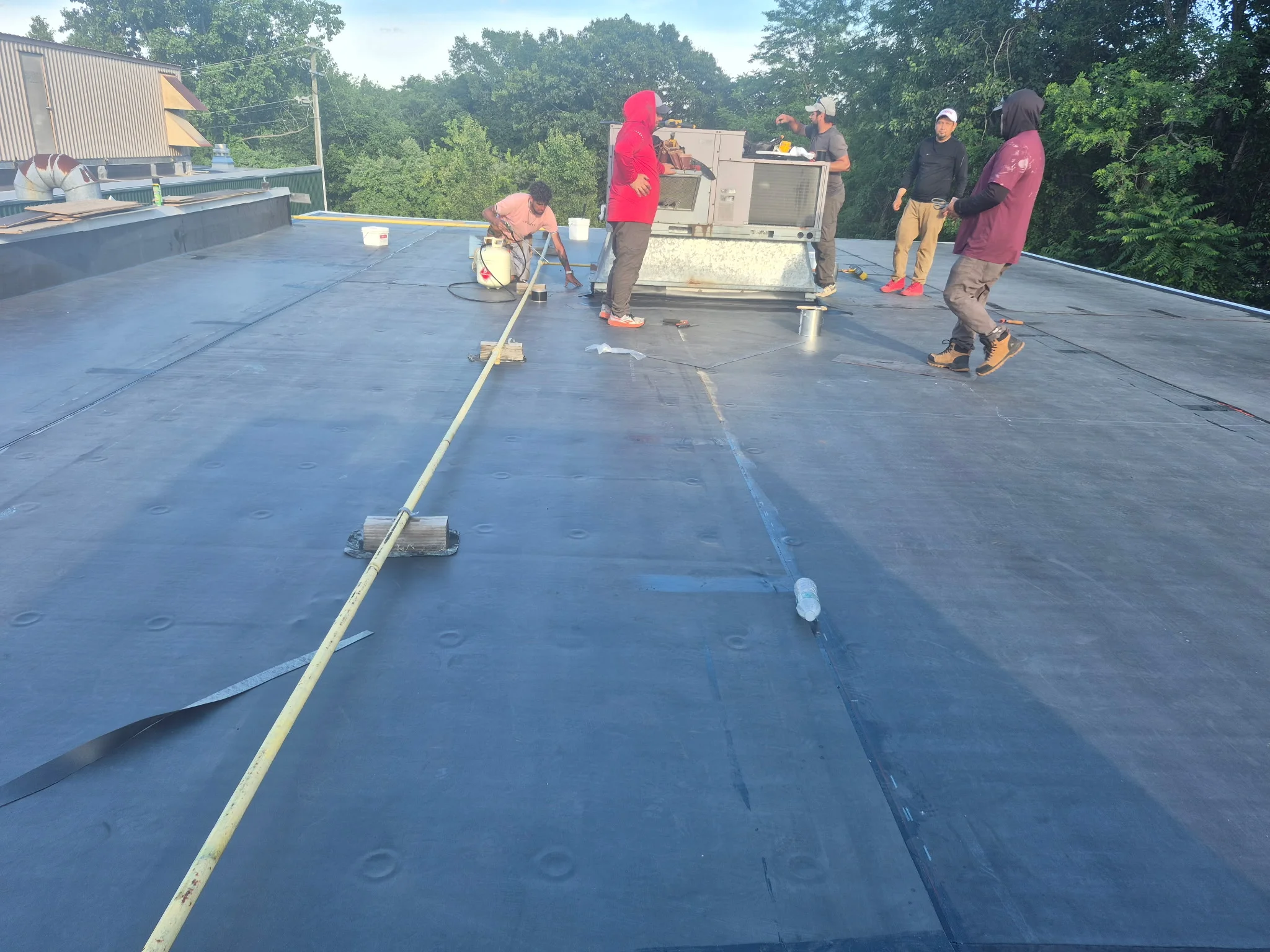 EPDM rubber membrane flat roof installation with seam sealing and fastener application