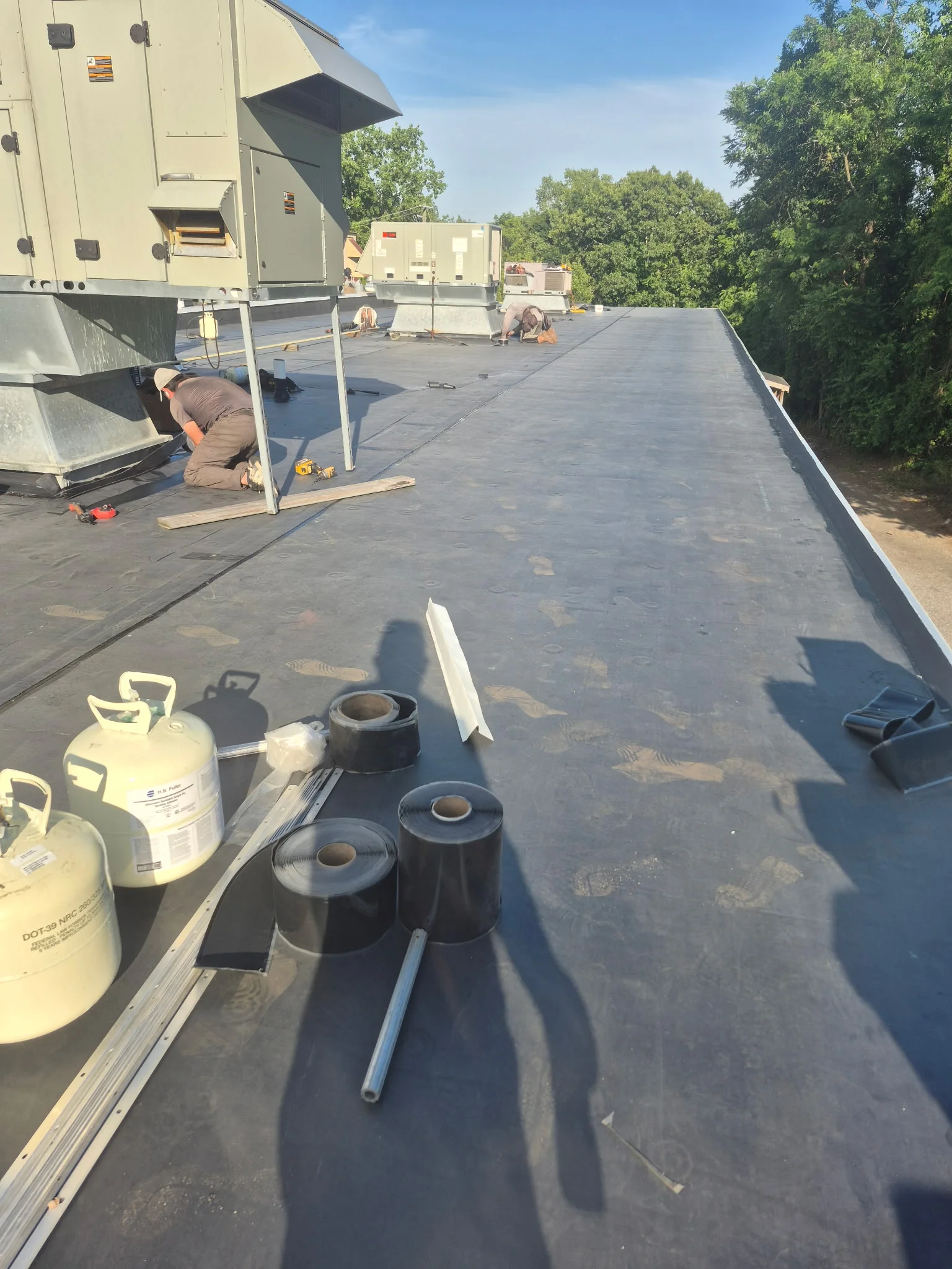 EPDM rubber membrane installation on commercial flat roof with flashing and sealing materials
